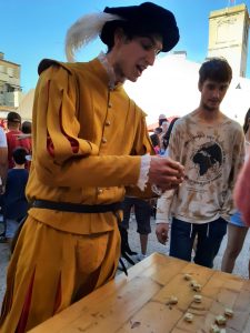 Explicación del juego de las tabas durante una recreación histórica